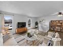 Bright living room with hardwood floors, neutral paint, large windows, and modern furniture at 10930 Albion Ct, Thornton, CO 80233