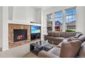 Bright living room with a stone fireplace, large windows, and comfortable seating at 3751 W 136Th Ave # L1, Broomfield, CO 80023