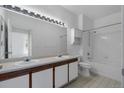 Bright bathroom with double sinks, large mirror with vanity lighting, and a shower-tub combo at 6017 Castlegate Dr # F15, Castle Rock, CO 80108
