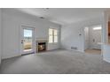 Cozy living room with a fireplace, plush carpet, and a door to the balcony at 6017 Castlegate Dr # F15, Castle Rock, CO 80108