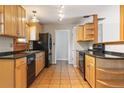 Bright kitchen featuring wood cabinets, black appliances and tile flooring at 2901 Lorraine Ct, Boulder, CO 80304