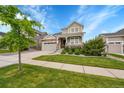 Charming two-story home with a covered porch, a stone facade, landscaped yard and an attached two-car garage at 8839 Culebra St, Arvada, CO 80007