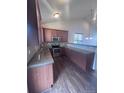 Functional kitchen featuring modern appliances, granite countertops, and wood cabinets at 1985 Basil St, Strasburg, CO 80136