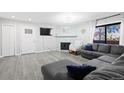 Bright living room with neutral decor, gray wood floors, and a cozy fireplace at 3345 S Ammons St # 5-102, Lakewood, CO 80227