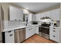 Modern kitchen features white cabinets, stainless steel appliances, and subway tile backsplash at 962 S Potomac Way, Aurora, CO 80012