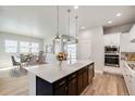 Modern kitchen with stainless steel appliances, quartz countertops, and a large center island at 21234 E 63Rd Dr, Aurora, CO 80019