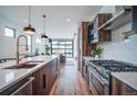 Kitchen showcases a large island with sink, stainless steel appliances, and an open concept living area at 4476 Utica St, Denver, CO 80212