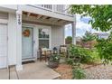 Inviting front porch with a quaint seating area and a welcoming, decorated front door at 249 Vista Blvd, Brighton, CO 80603