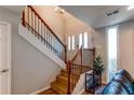 Inviting entryway with wood stairs, a white handrail with iron spindles and bright natural light at 2870 S Ursula St, Aurora, CO 80014