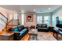 Open-concept space with living room, stairs, hardwood floors, and large sunny windows at 2870 S Ursula St, Aurora, CO 80014
