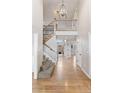 Bright foyer featuring hardwood floors, staircase with iron railings, and a view into the living area at 6681 Secrest Cir, Arvada, CO 80007