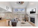 Cozy living room with a fireplace, large windows, and elegant furnishings at 6681 Secrest Cir, Arvada, CO 80007