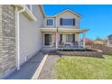 Inviting two-story house with gray siding, a well-kept lawn, and a cozy porch with seating at 5912 Randolph Ave, Castle Rock, CO 80104