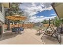 Inviting backyard patio with dining set, swing, and storage shed at 1062 Jasper St, Aurora, CO 80011
