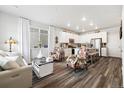 Bright living room flowing into an open kitchen, featuring modern finishes and plenty of natural light at 12570 Boggs St, Parker, CO 80134