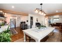 Bright dining area features hardwood floors and modern light fixture at 6361 S Spotswood Cir, Littleton, CO 80120
