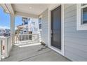 View of the home's covered front porch area with white railings and a gray front door at 305 Welded Tuff Trl, Castle Rock, CO 80104