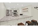 This modern kitchen features granite countertops, stainless steel appliances and bar stool seating at 8055 E Colorado Ave # 8, Denver, CO 80231