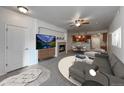 Staged living room with a fireplace, modern furniture, and an open layout to the kitchen at 2239 Calais Dr # E, Longmont, CO 80504