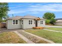Side view of updated single-story home with tidy lawn, quaint entry, and mature trees at 5100 Clay St, Denver, CO 80221