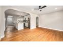Bright, open living room with beautiful hardwood floors and arched entry to the kitchen at 5100 Clay St, Denver, CO 80221