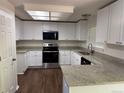 Updated kitchen features stainless appliances, granite countertops, and white cabinets at 13959 Eudora St, Thornton, CO 80602
