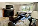Comfortable living room featuring a leather sectional sofa, fireplace, and light-filled windows at 4934 S Flower Way, Littleton, CO 80123