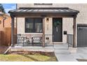 Charming front porch with stone columns, black metal railing, and a cozy seating area at 1157 Jersey St, Denver, CO 80220