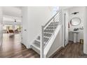 Modern hallway featuring a staircase with metal railings and a view into the living room at 10917 Mobile St, Commerce City, CO 80022