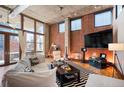 Bright living room featuring exposed brick, hardwood floors, and a cozy seating area with large windows at 1720 Wazee St # 3B, Denver, CO 80202