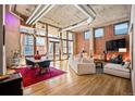 Stylish living room with exposed brick, hardwood floors, large windows, and a comfortable seating area at 1720 Wazee St # 3B, Denver, CO 80202