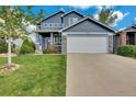Two-story home with blue siding, stone accents, an attached two-car garage, and a well-maintained lawn at 10882 Bullock Ct, Parker, CO 80134