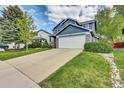 Two-story home with blue siding, stone accents, two-car garage, and a spacious driveway at 10882 Bullock Ct, Parker, CO 80134