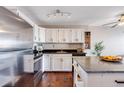 Modern kitchen features white cabinets, granite counters, stainless steel appliances, and wood floors with a stylish island at 1121 Albion St # 803, Denver, CO 80220