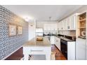 Stylish kitchen featuring granite counters, white cabinets, black hardware, and bold patterned wallpaper with modern art at 1121 Albion St # 803, Denver, CO 80220