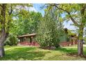 Charming single-story home with lush front yard, brick accents, and mature trees at 850 Idalia Cir, Aurora, CO 80011