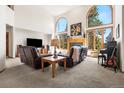 Spacious living room with large windows, fireplace, and comfortable seating at 6252 King Dr, Evergreen, CO 80439