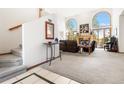 Bright living room featuring high ceilings, arched windows, and a cozy fireplace at 6252 King Dr, Evergreen, CO 80439