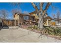 Cozy home featuring a wooden deck, brick accents, and a two-car attached garage at 4593 S Field St, Littleton, CO 80123
