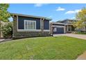 Well-manicured front lawn showcases the home's lovely exterior, complemented by beautiful stonework at 2485 Vale Way, Erie, CO 80516