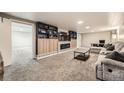 Finished basement with plush carpeting, custom built-ins surrounding a fireplace, and a comfortable seating area at 1819 S Nile Ct, Aurora, CO 80012