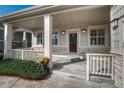 Inviting front porch with decorative columns, charming door, and fresh landscaping at 8107 S Catawba Ct, Aurora, CO 80016