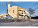 Side view of tan multi-unit building with stone retaining wall at 13651 E Yale Ave # C, Aurora, CO 80014