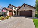 A charming home with a three-car garage, a manicured lawn, and an American flag in a flower-filled window box at 6266 W Prentice Ave, Littleton, CO 80123