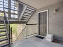 Exterior entryway of unit 201 featuring stairs, dark door, and Riddwell box at 2575 S Syracuse Way # K201, Denver, CO 80231