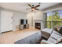 Cozy living room with fireplace, TV, sliding glass door to balcony and comfortable gray sofa at 2575 S Syracuse Way # K201, Denver, CO 80231