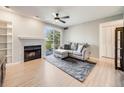 Bright living room with fireplace, shelves, sliding glass door to balcony and comfortable gray sofa at 2575 S Syracuse Way # K201, Denver, CO 80231