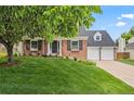 Lovely brick home with manicured lawn and a mature tree in the front yard at 6839 S Niagara Ct, Centennial, CO 80112
