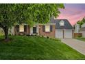 Beautiful brick home with a well-manicured lawn and mature shade tree at 6839 S Niagara Ct, Centennial, CO 80112
