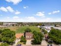 Expansive aerial view of a neighborhood with a lush green field and diverse housing options, showcasing community living at 6318 Newton Ct, Arvada, CO 80003